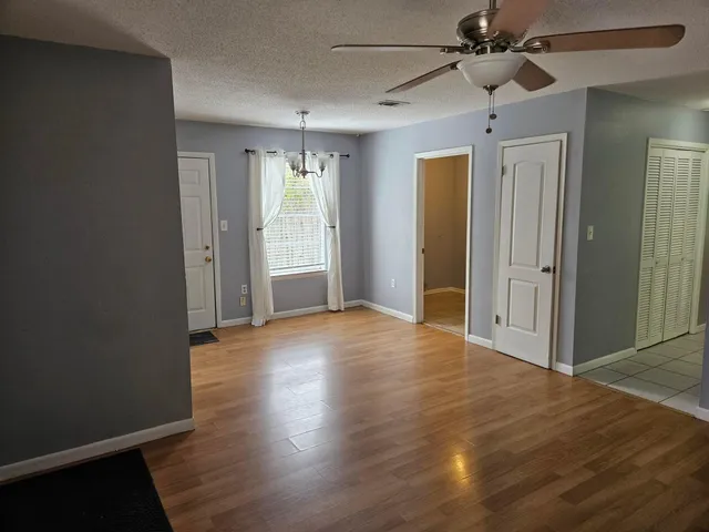 an empty room with wooden floor a ceiling fan and closet