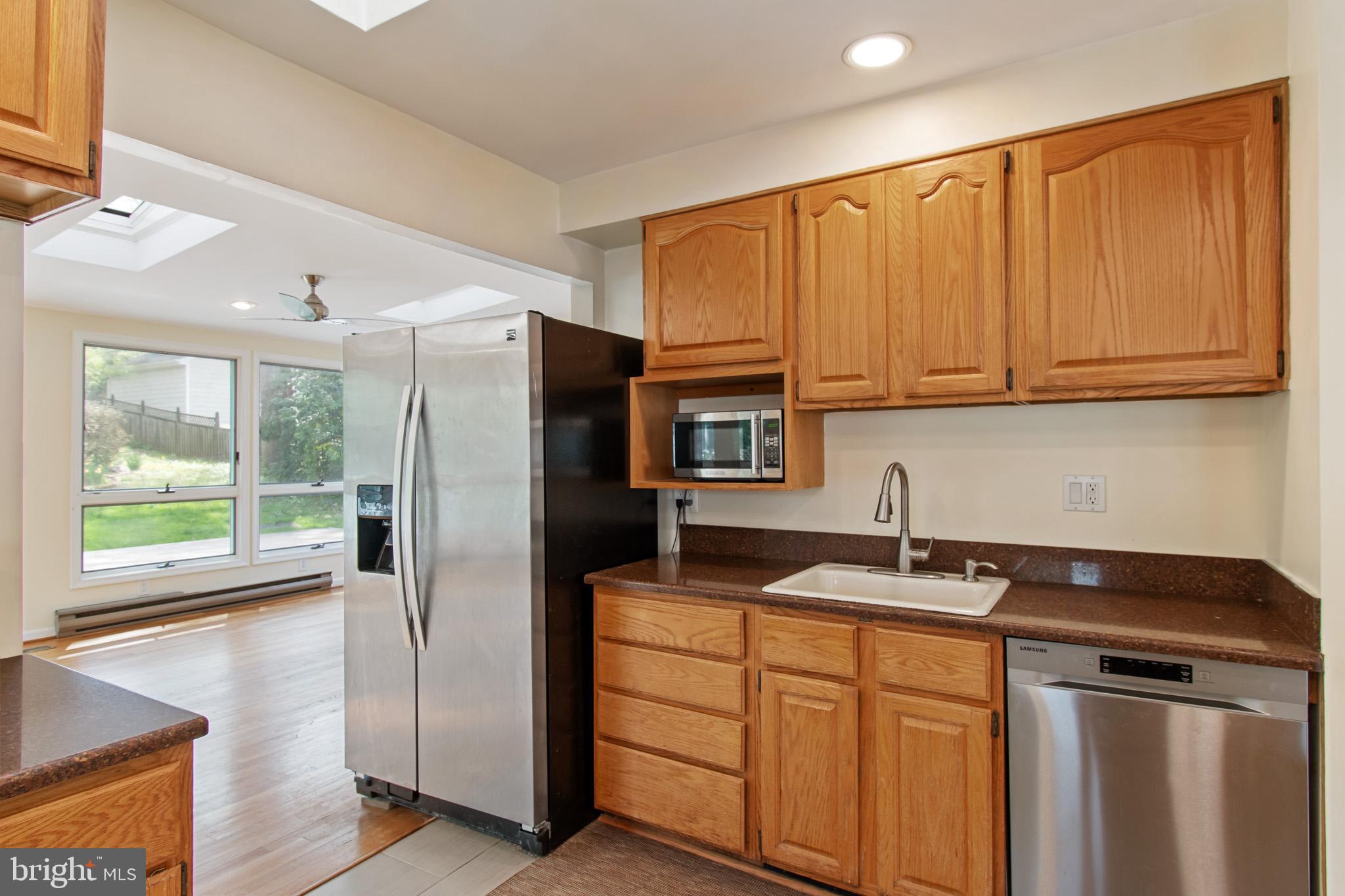 512 Carr Avenue Rockville, MD 20850 - Photo 26 of 56 a kitchen with stainless steel appliances granite countertop a refrigerator a sink and white cabinets with wooden floor