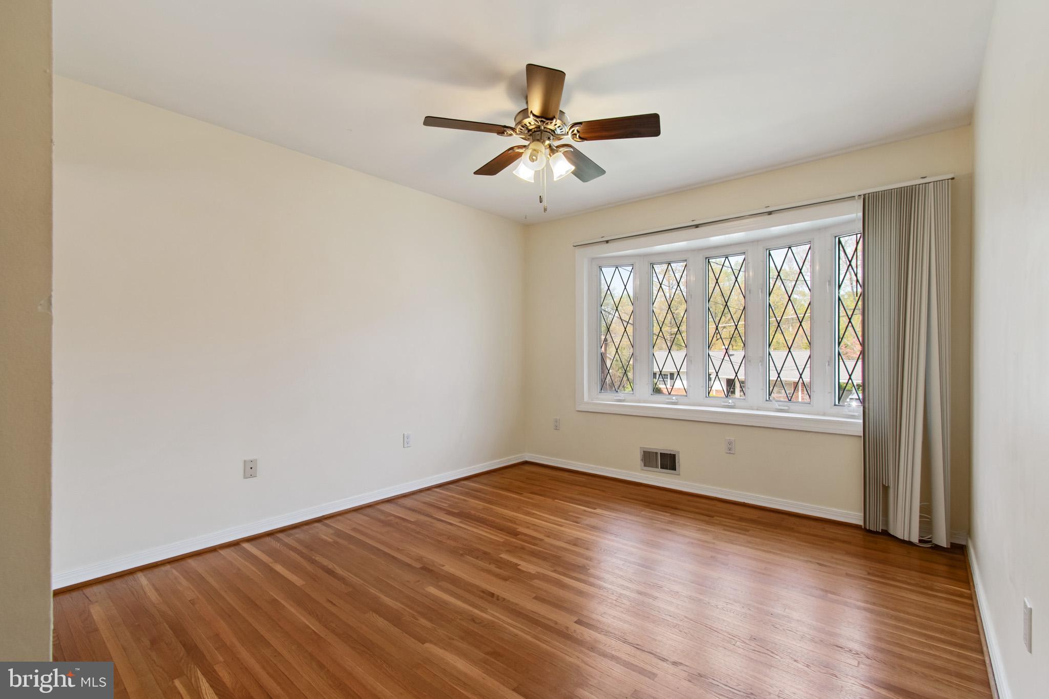 512 Carr Avenue Rockville, MD 20850 - Photo 36 of 56 an empty room with wooden floor chandelier fan and windows
