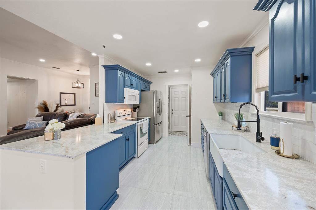 a large kitchen with stainless steel appliances lots of counter space and a sink