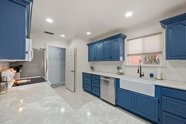 a kitchen with a sink a stove and cabinets
