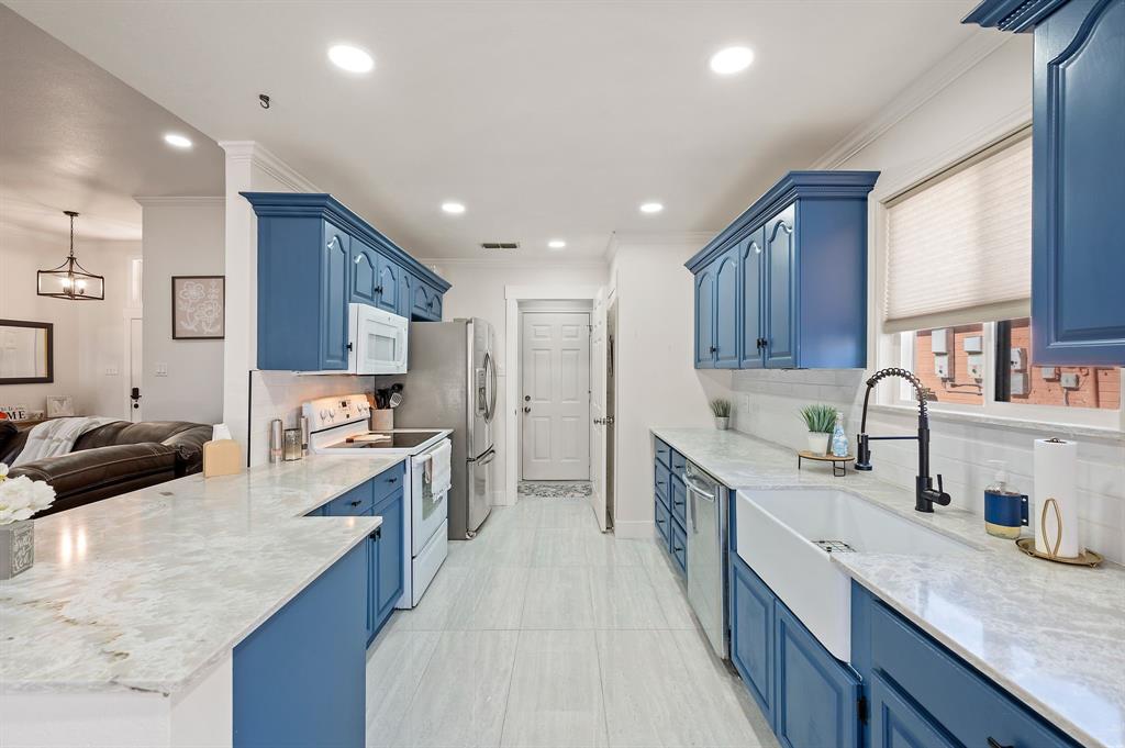 305 Maverick Trail Oak Point, TX 75068 - Photo 18 of 40 a kitchen with stainless steel appliances granite countertop sink stove refrigerator and cabinets