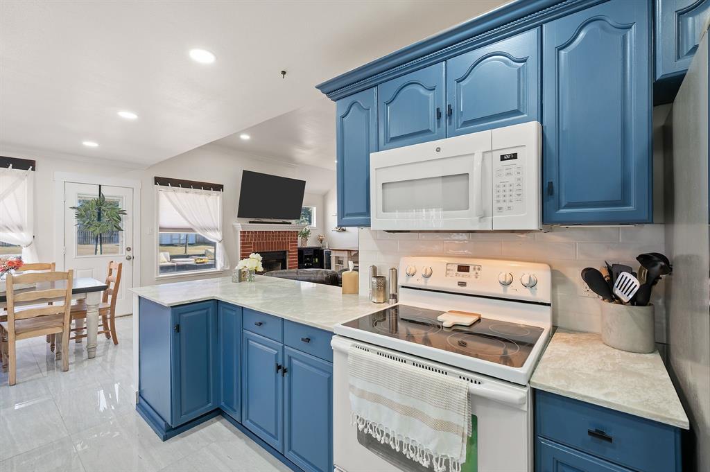 305 Maverick Trail Oak Point, TX 75068 - Photo 19 of 40 a kitchen with granite countertop a sink a stove and cabinets