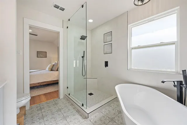 a bathroom with a tub shower and mirror
