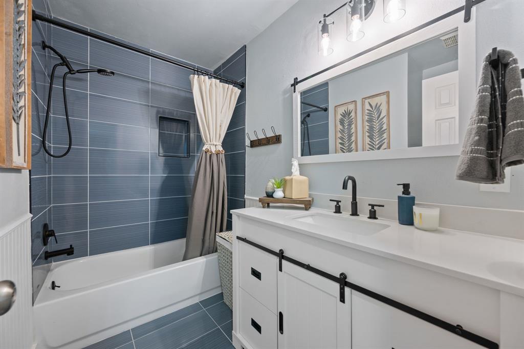 305 Maverick Trail Oak Point, TX 75068 - Photo 28 of 40 a bathroom with a granite countertop sink a mirror a bathtub and shower