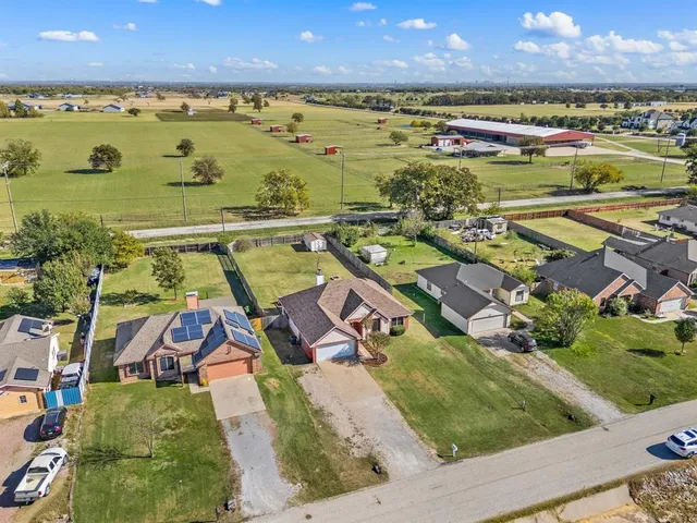 an aerial view of ocean and residential houses with outdoor space