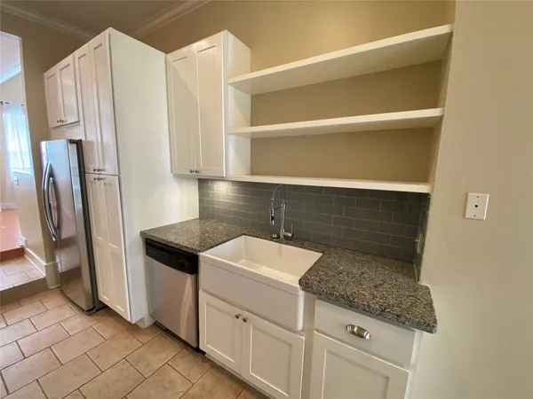 a kitchen with granite countertop a sink and a refrigerator