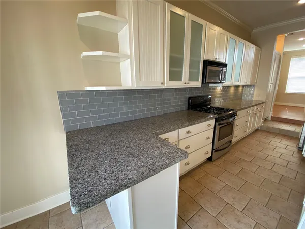 a kitchen with stainless steel appliances granite countertop a sink stove and microwave