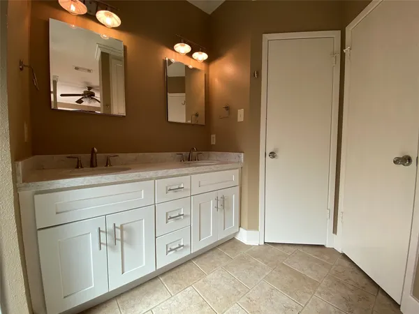 a spacious bathroom with a double vanity sink and a mirror