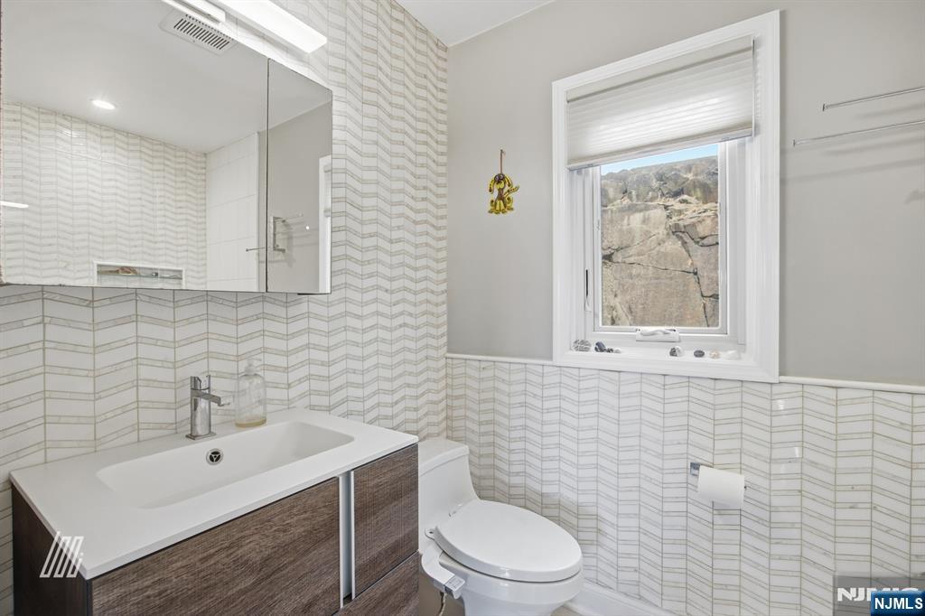 300 Gorge Road, Unit 75 Cliffside Park, NJ 07010 - Photo 17 of 27 a bathroom with a toilet a sink a mirror and a window