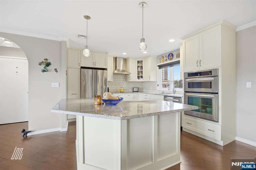 300 Gorge Road, Unit 75 Cliffside Park, NJ 07010 - Photo 7 of 27 a kitchen with kitchen island a sink stainless steel appliances and white cabinets