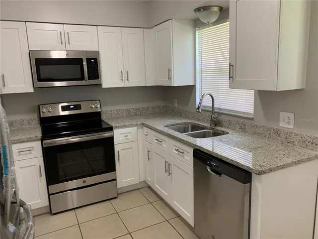a kitchen with a sink stove and microwave
