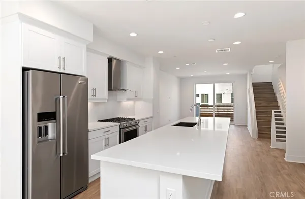 a kitchen with stainless steel appliances kitchen island a refrigerator and a stove top oven
