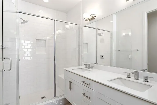 a bathroom with a double vanity sink mirror double and shower