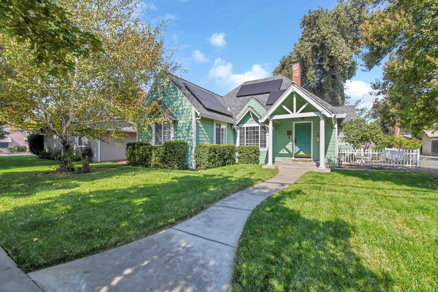 a front view of a house with a yard and trees
