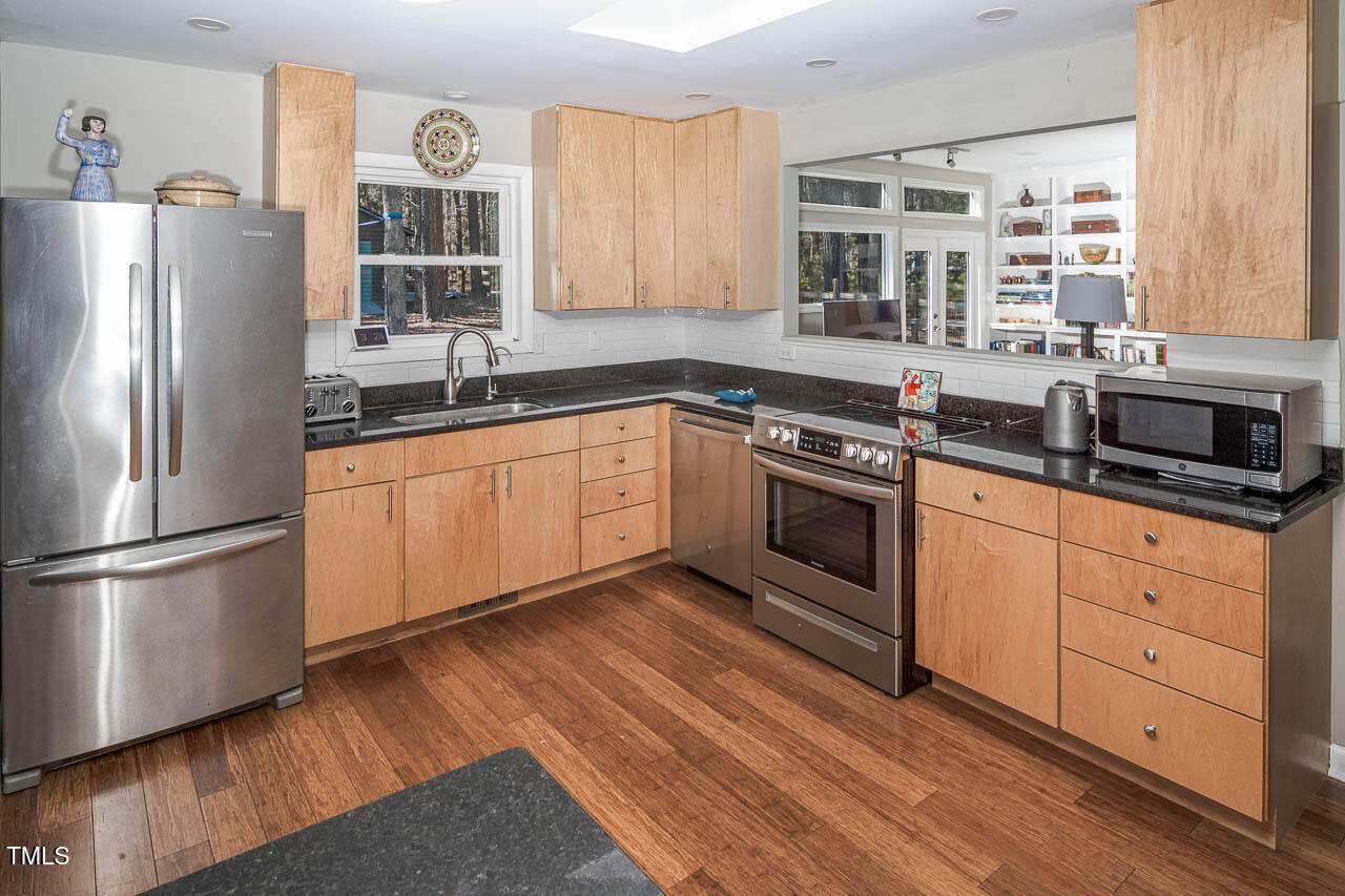 9501 Coachway Chapel Hill, NC 27516 - Photo 13 of 47 a kitchen with stainless steel appliances granite countertop a stove a sink and a refrigerator
