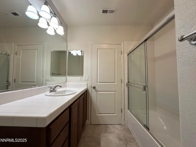 a bathroom with a sink a mirror and a shower