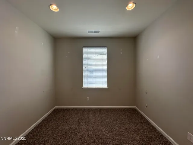 en empty room with windows and ceiling fan