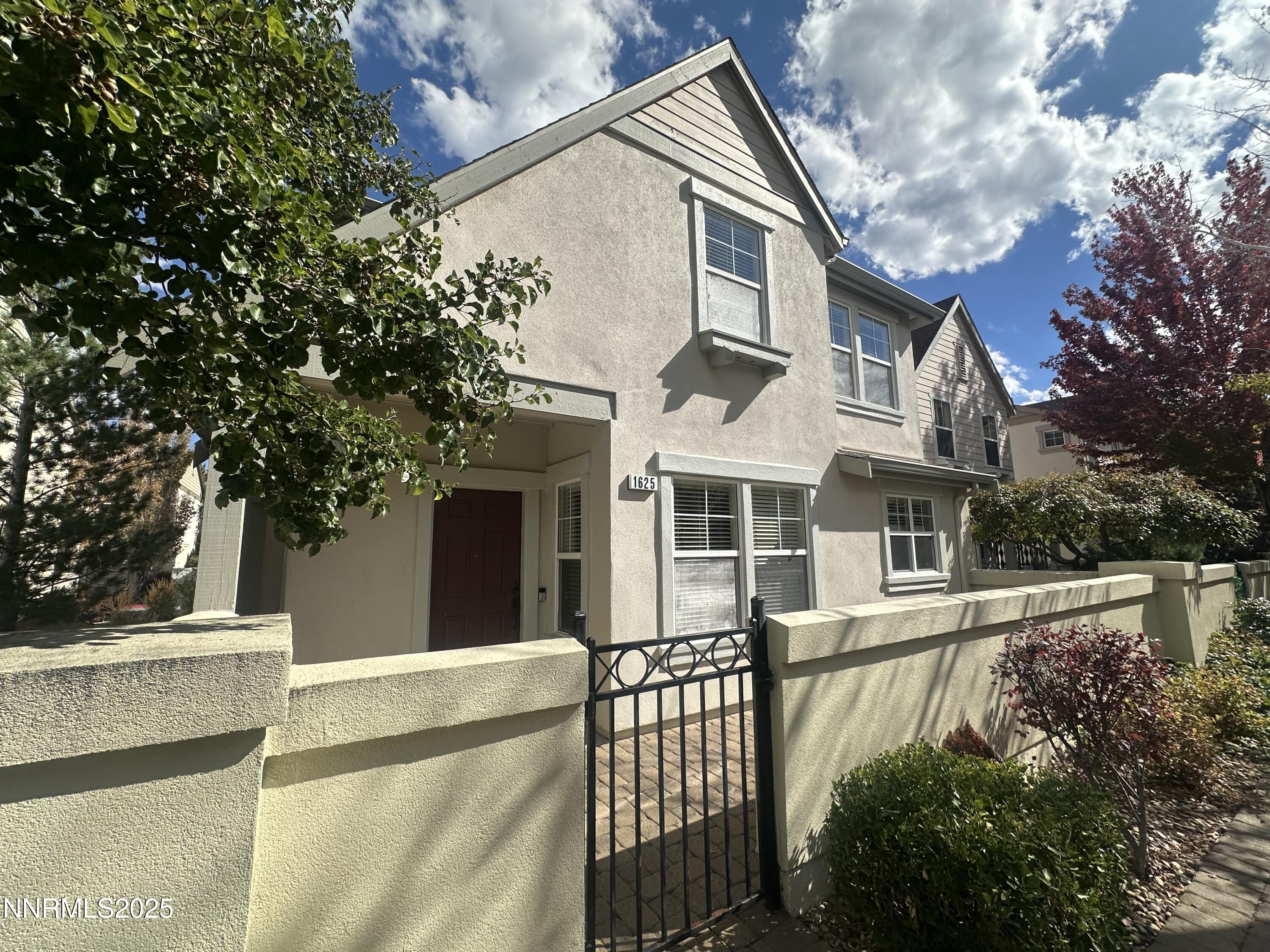 1625 Clover Hill Trail Reno, NV 89523 - Photo 5 of 41 a view of a white house with a large tree and wooden fence