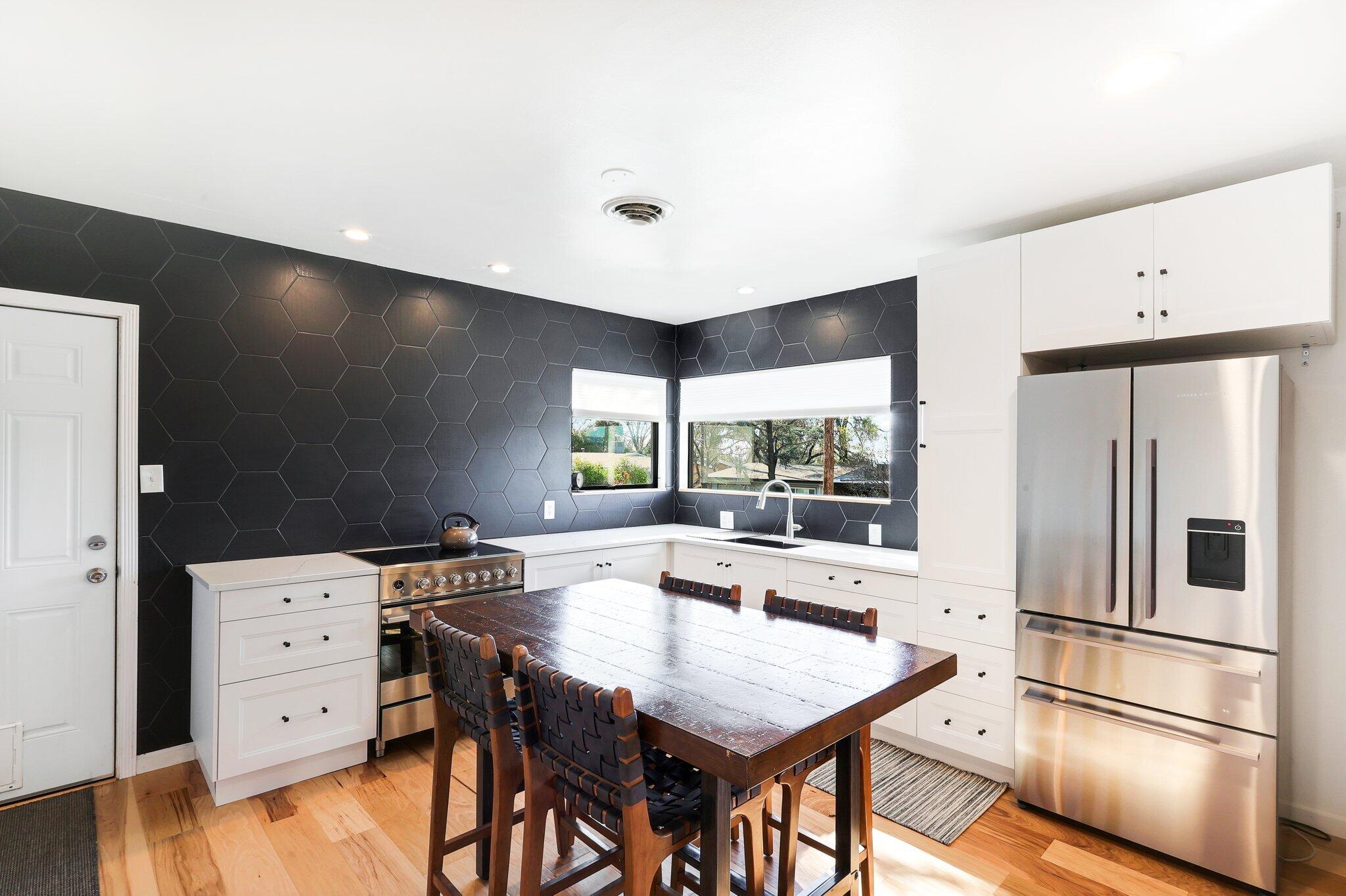 1750 Barbara Road Redding, CA 96003 - Photo 8 of 21 a kitchen with a refrigerator a stove a dining table and chairs