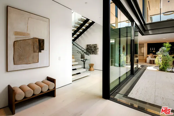 a living room with furniture flat screen tv and a large window