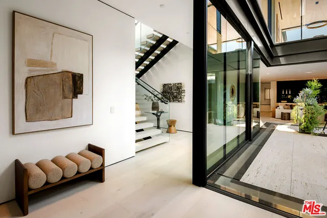 a living room with furniture flat screen tv and a large window