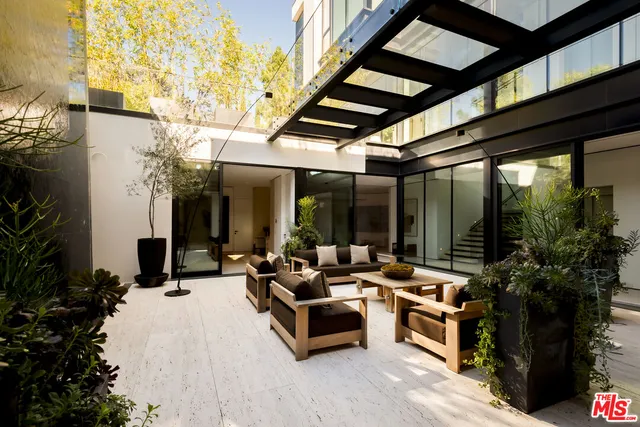 a view of a terrace with couches and a potted plant on a table