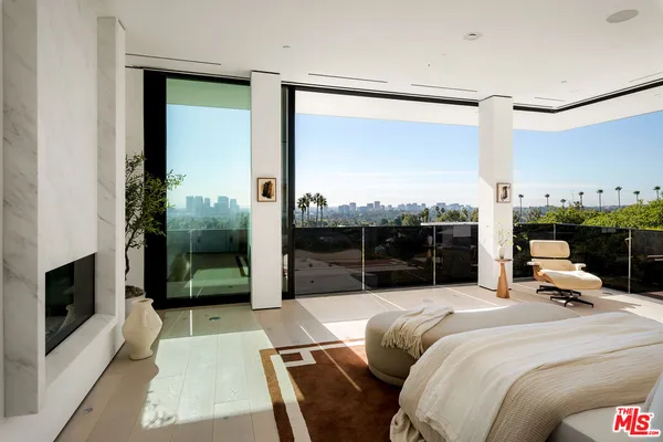 a bedroom with a bed and a balcony view