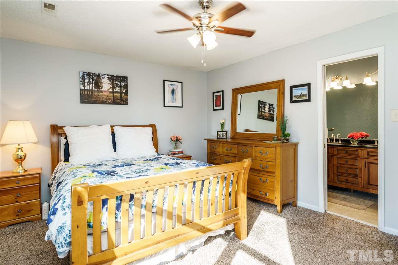 5532 Hamstead Crossing Raleigh, NC 27612 - Photo 14 of 25 a bedroom with a bed and a chandelier
