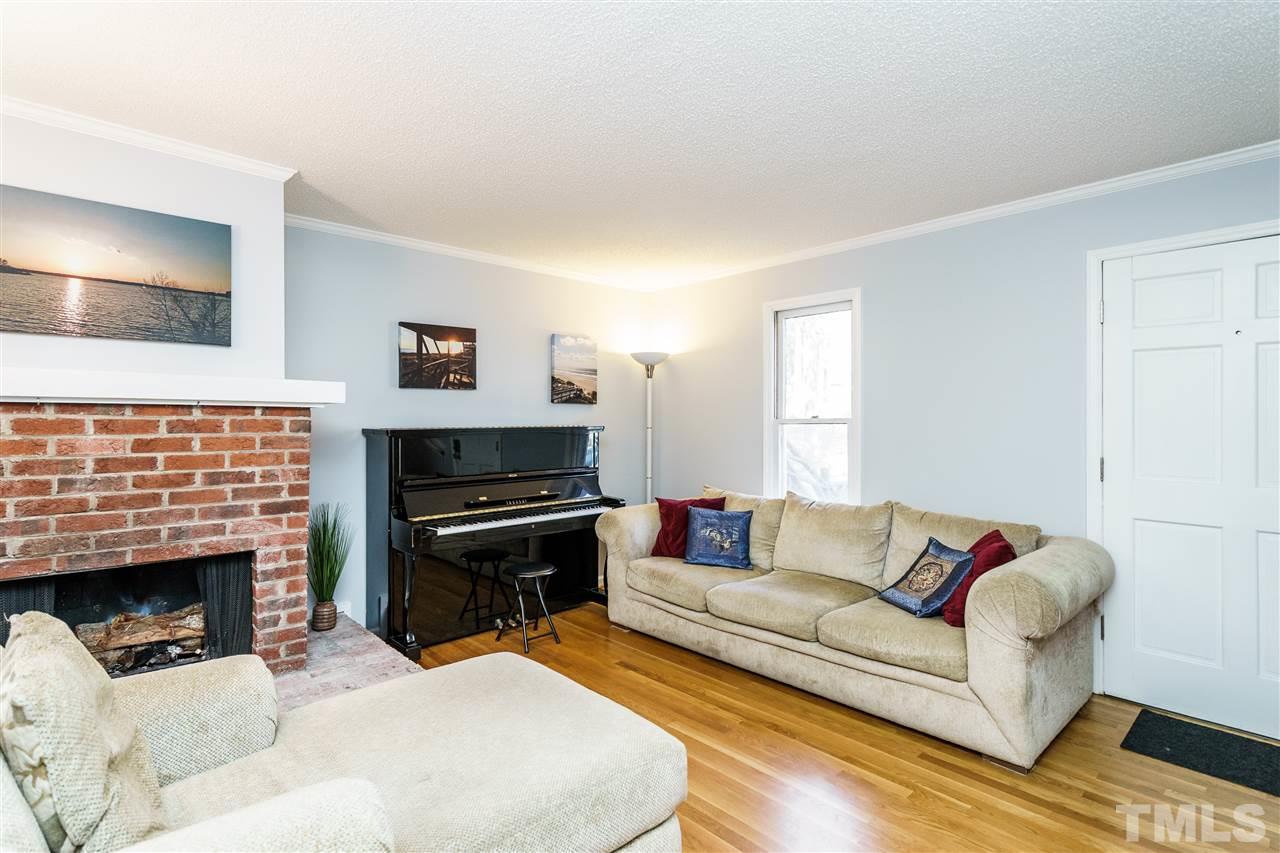 5532 Hamstead Crossing Raleigh, NC 27612 - Photo 5 of 25 a living room with furniture a flat screen tv and a fireplace