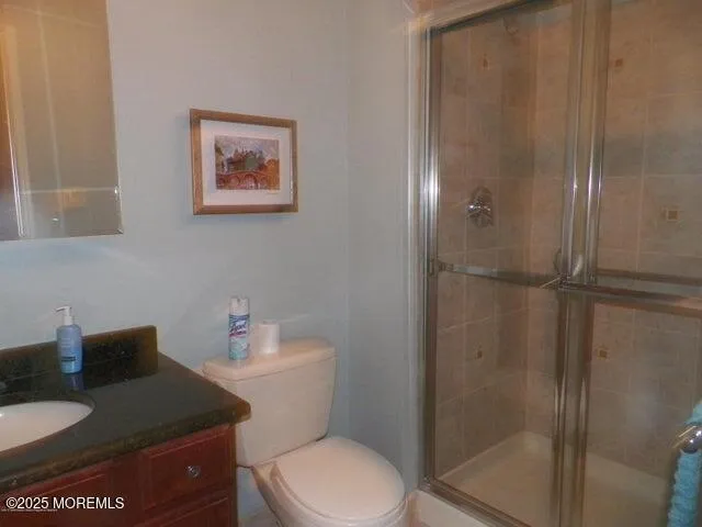 a bathroom with a granite countertop toilet and a shower