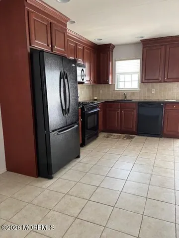 a kitchen with stainless steel appliances granite countertop a stove a refrigerator and a sink