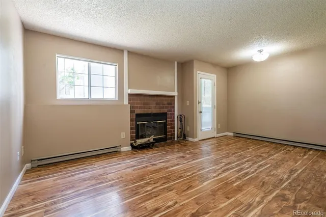 an empty room with windows and a fireplace