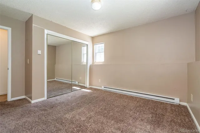 an empty room with windows and closet