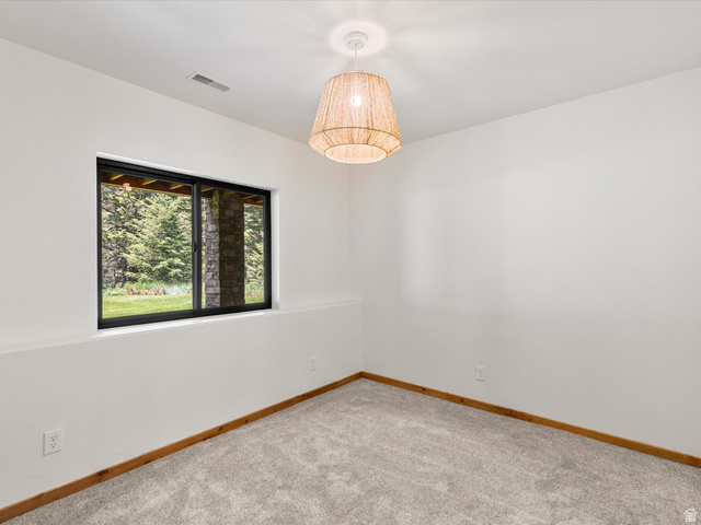 1225 Old Oregon Road Soda Springs, ID 83276 - Photo 23 of 67 Room featuring a large window, neutral carpeting, and a woven pendant light fixture