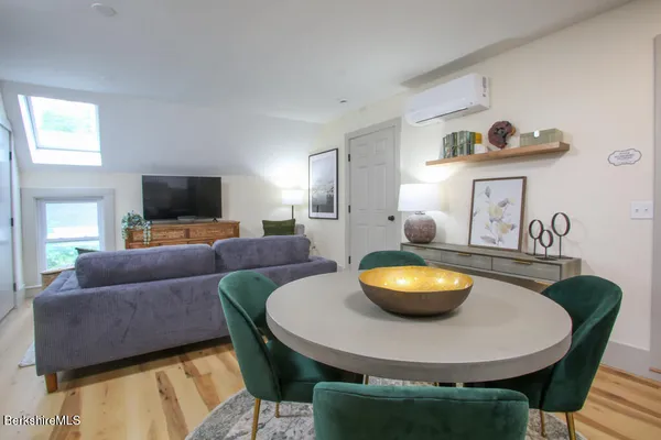 a living room with stainless steel appliances furniture and a view of kitchen