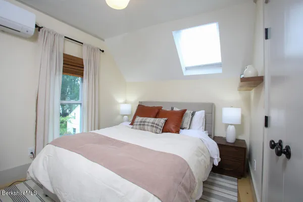 a bedroom with bed and wooden floor