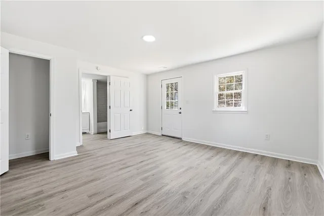 an empty room with wooden floor and windows