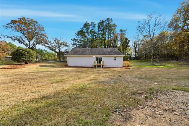 a view of a house with a yard and trees