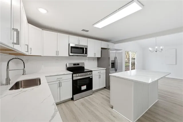 a kitchen with a sink a stove a microwave and refrigerator