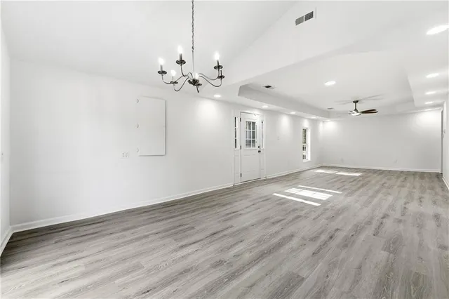 a view of empty room with wooden floor and ceiling fan