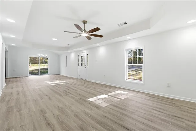 a view of an empty room with a window and wooden floor