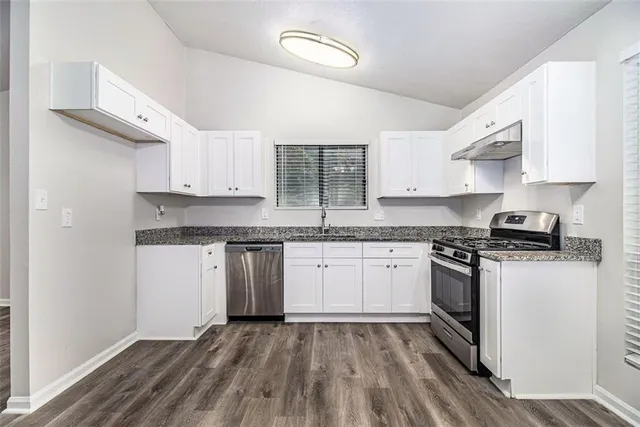 a kitchen with stainless steel appliances granite countertop a stove and a sink