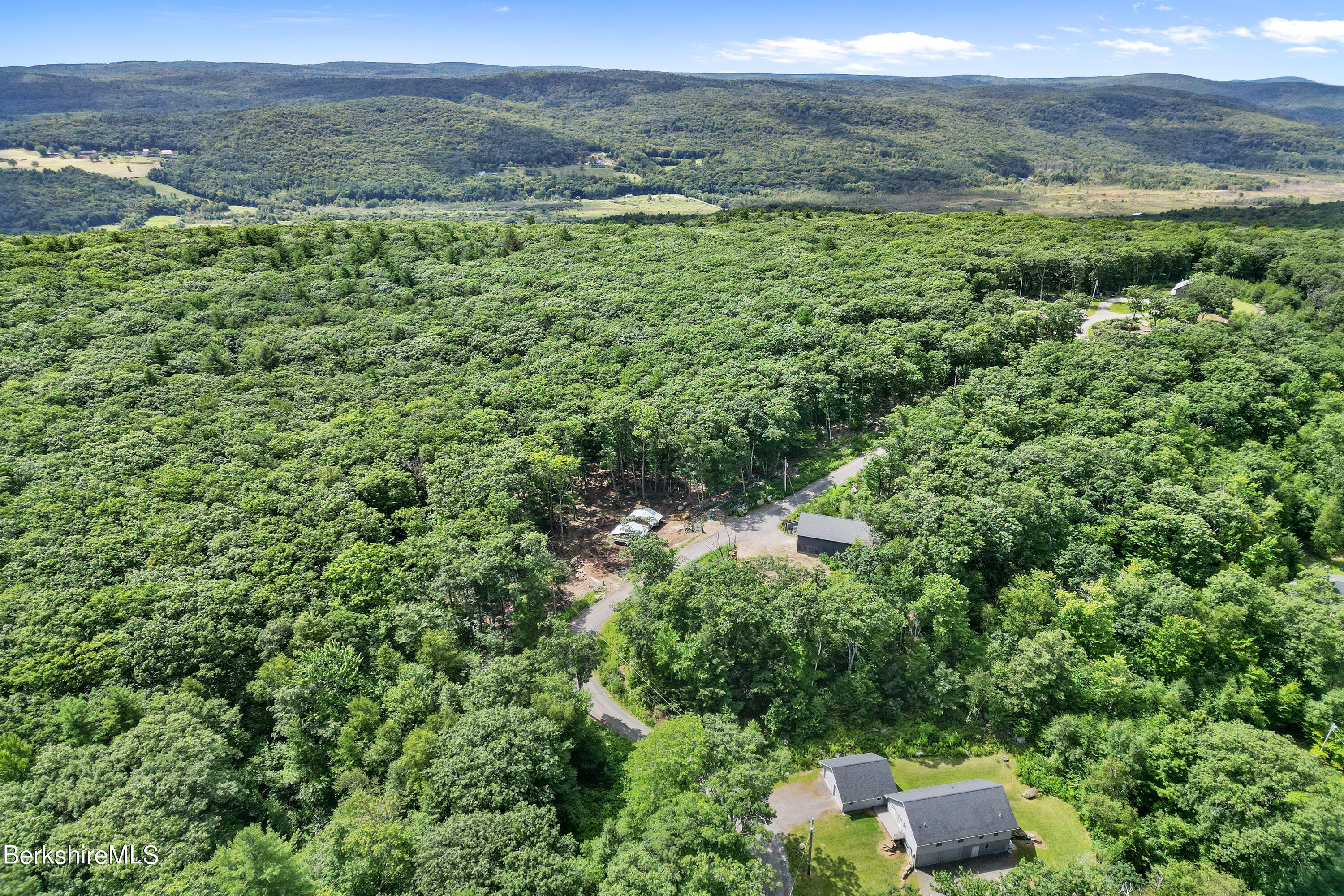26 A Stonebridge Way Tyringham, MA 01238 - Photo 70 of 74 a view of a lush green forest with trees and some houses