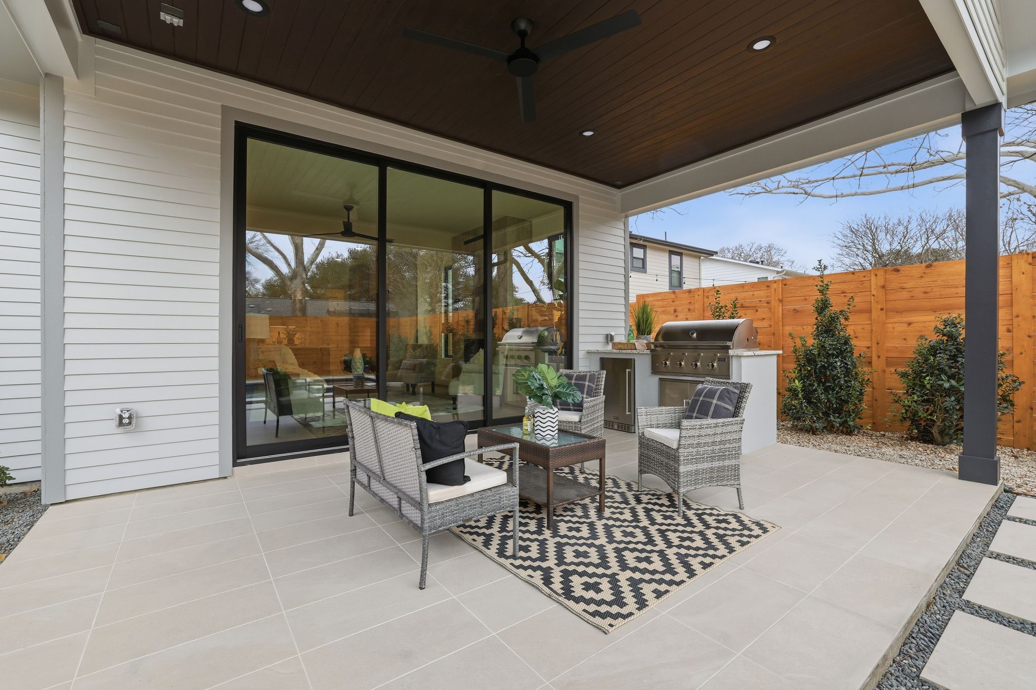 6611 Lexington Road Austin, TX 78757 - Photo 33 of 37 Covered patio featuring a built-in outdoor kitchen with grill, wood slat fencing, and large format patio tiles