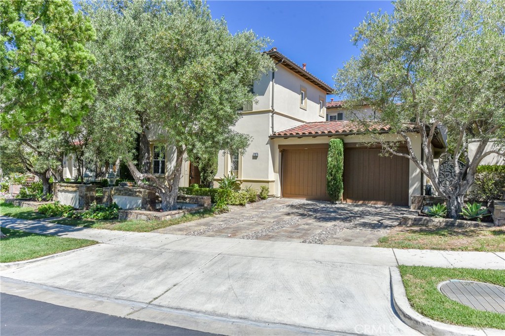 a view of a house with a yard and large tree