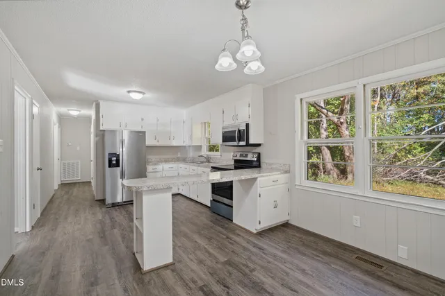 a kitchen with stainless steel appliances a refrigerator stove and microwave