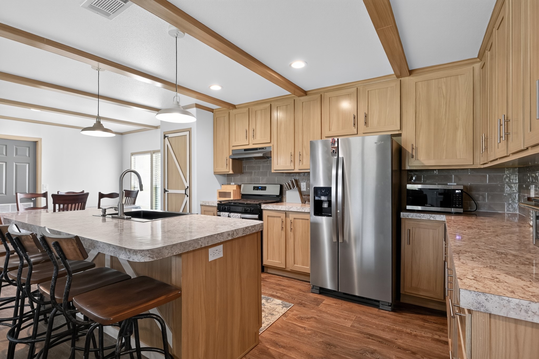 1134 Switchgrass Road Salado, TX 76571 - Photo 3 of 28 A well-appointed kitchen features wood-beamed ceilings, durable laminate countertops, and modern stainless steel appliances.