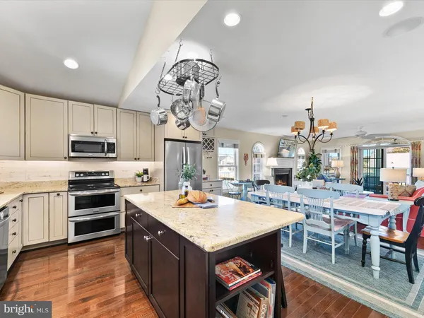 a dining room with wooden floor a chandelier a wooden table and chairs