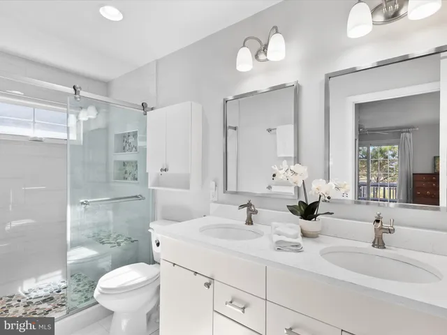 a view of a hallway to a livingroom with wooden floor and stairs